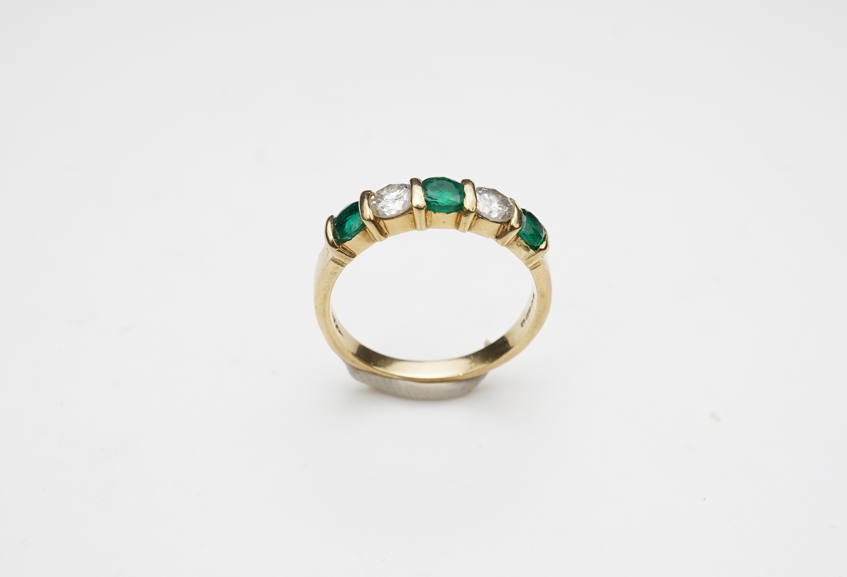 An emerald and diamond five-stone ring